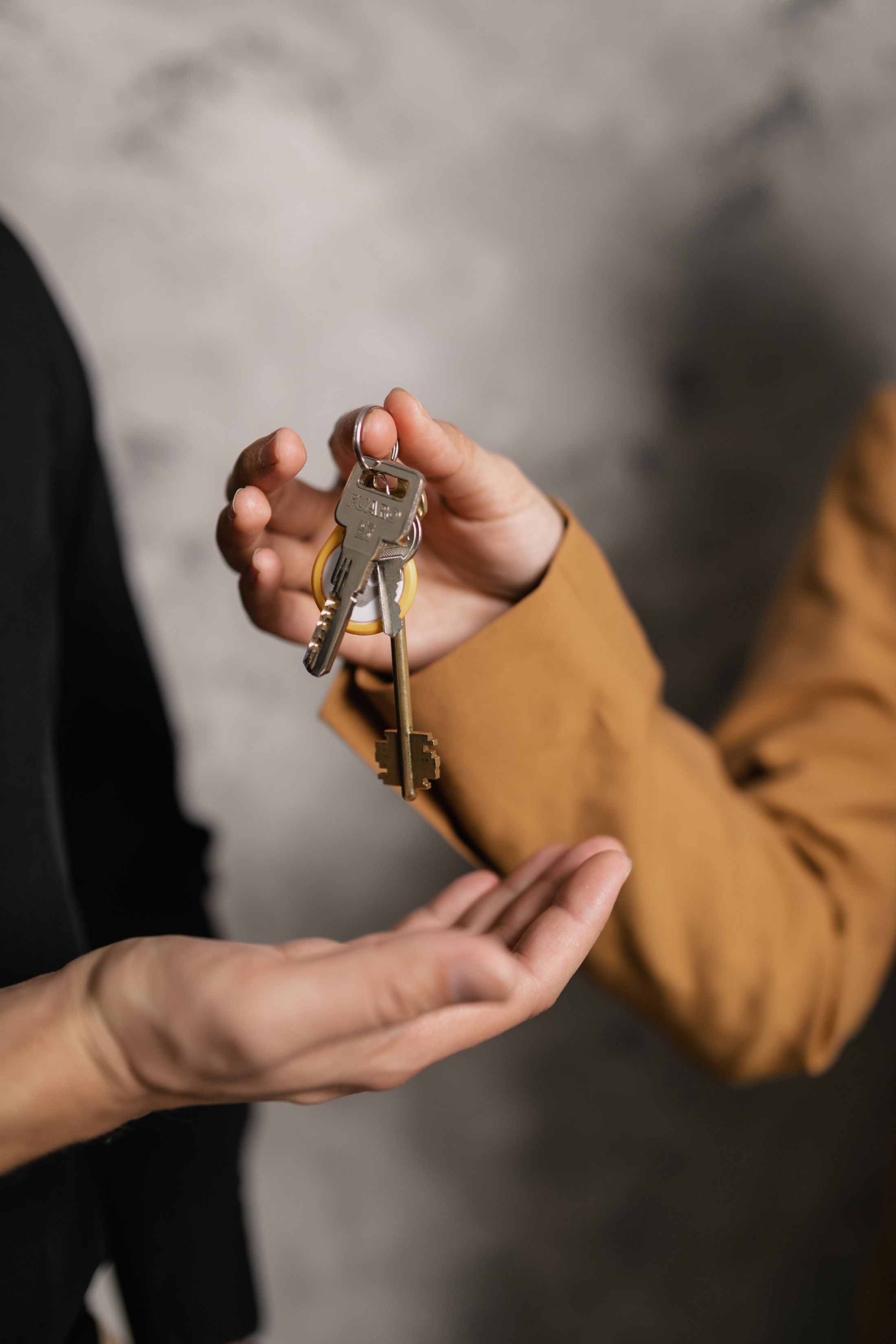 House keys being passed between two hands